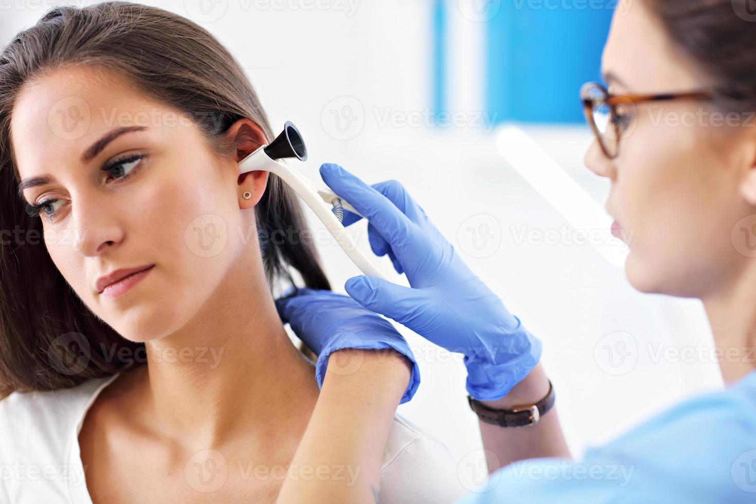 femme adulte ayant une visite au bureau du laryngologue féminin photo