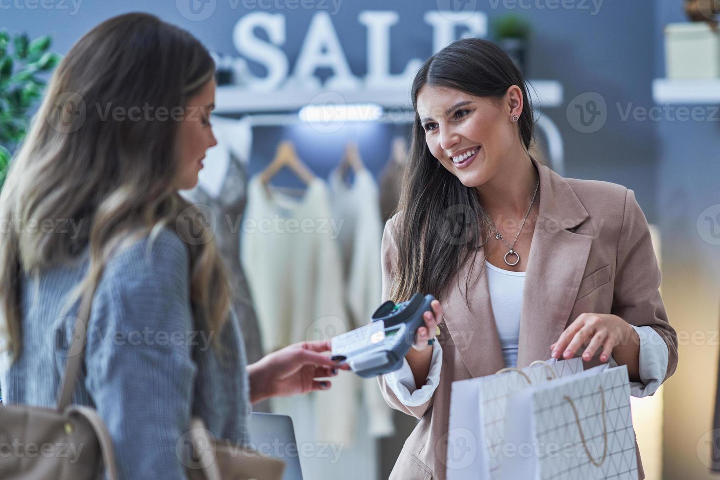 vendeuse et acheteuse dans un magasin de vêtements photo