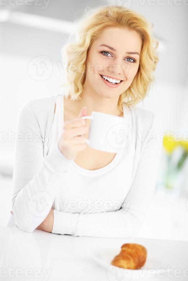 jeune femme buvant du café dans la cuisine photo