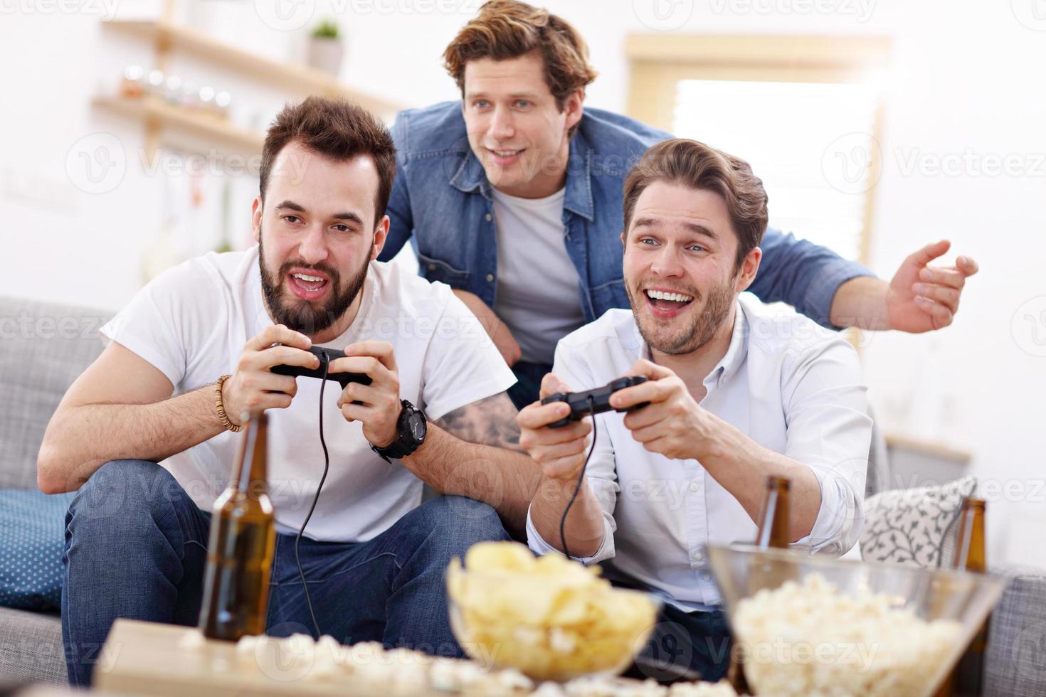 amis s'amusant sur le canapé avec des jeux vidéo photo