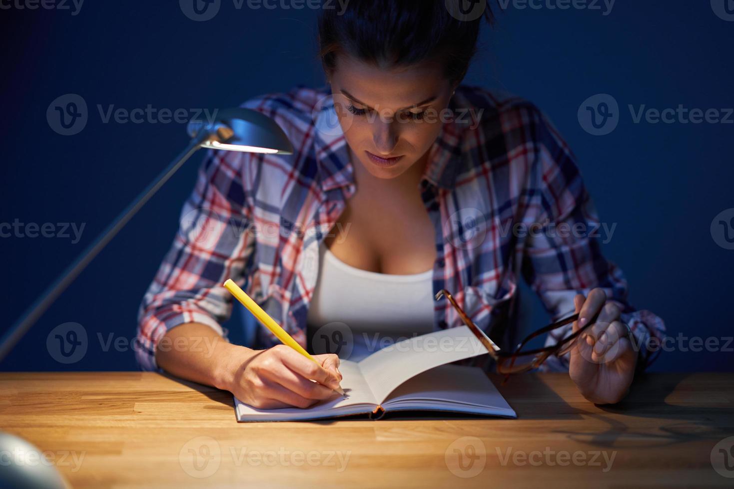 Étudiante fatiguée apprenant jusque tard à la maison photo