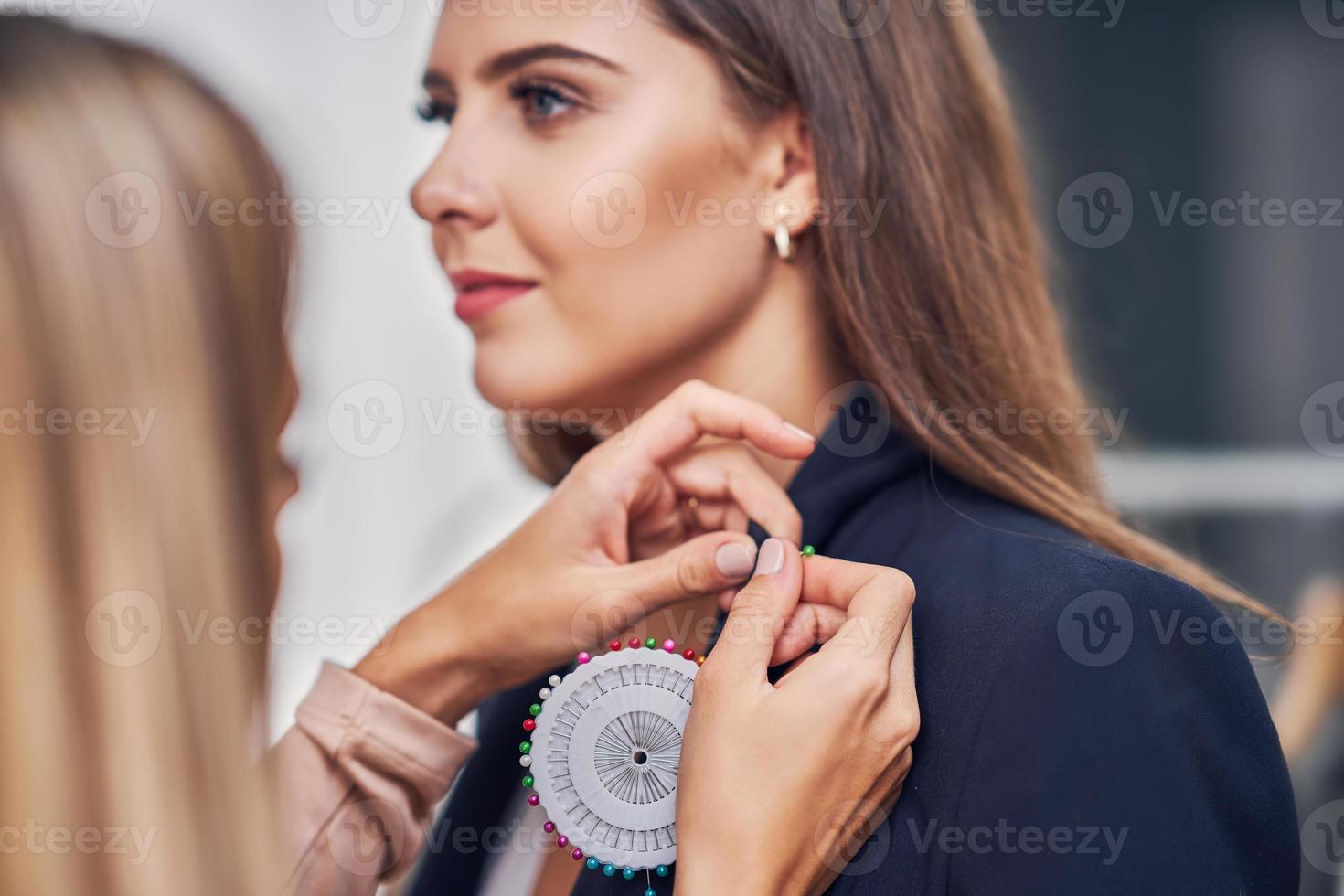 créateur de mode assistant le client dans la boutique de vêtements photo