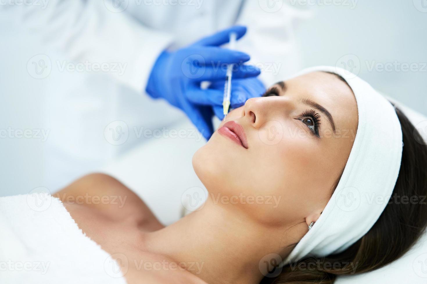 belle jeune femme recevant un traitement du visage acide au salon de beauté. photo