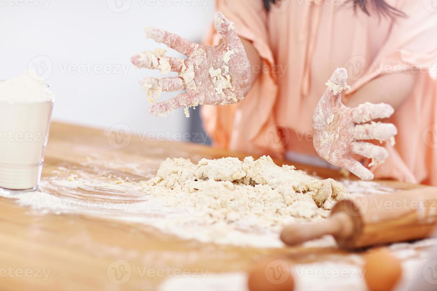 jeune femme essayant de faire du pierogi dans la cuisine photo