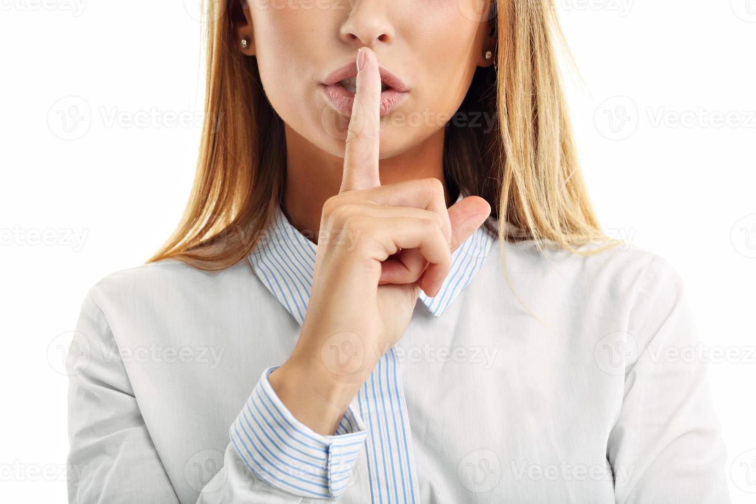 femme adulte tenant un doigt sur ses lèvres sur fond blanc photo