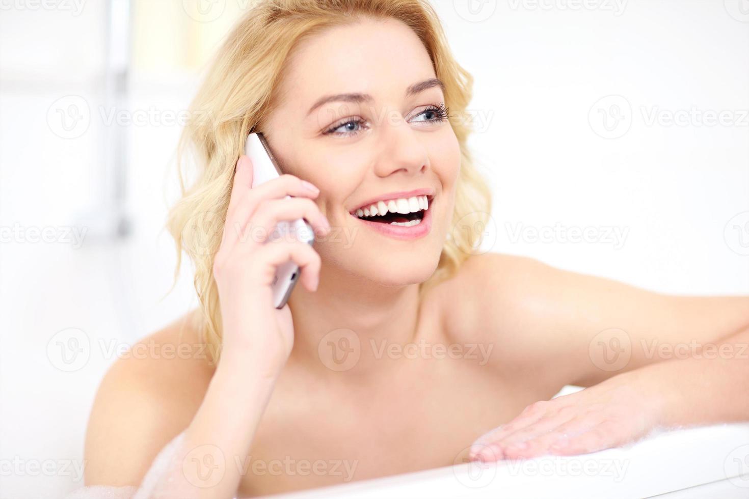 femme parlant au téléphone en prenant un bain photo