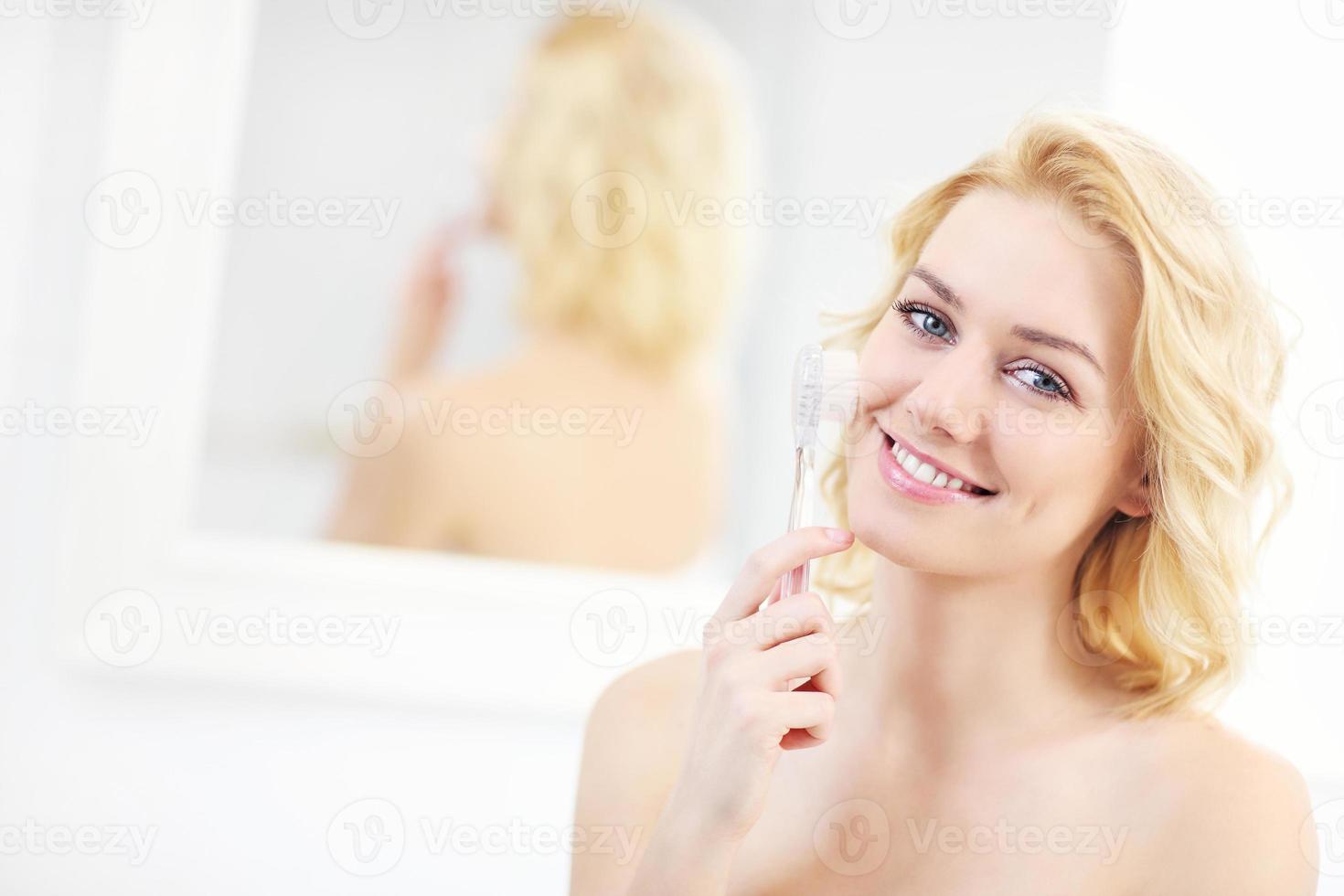 femme utilisant une brosse nettoyante pour le visage photo