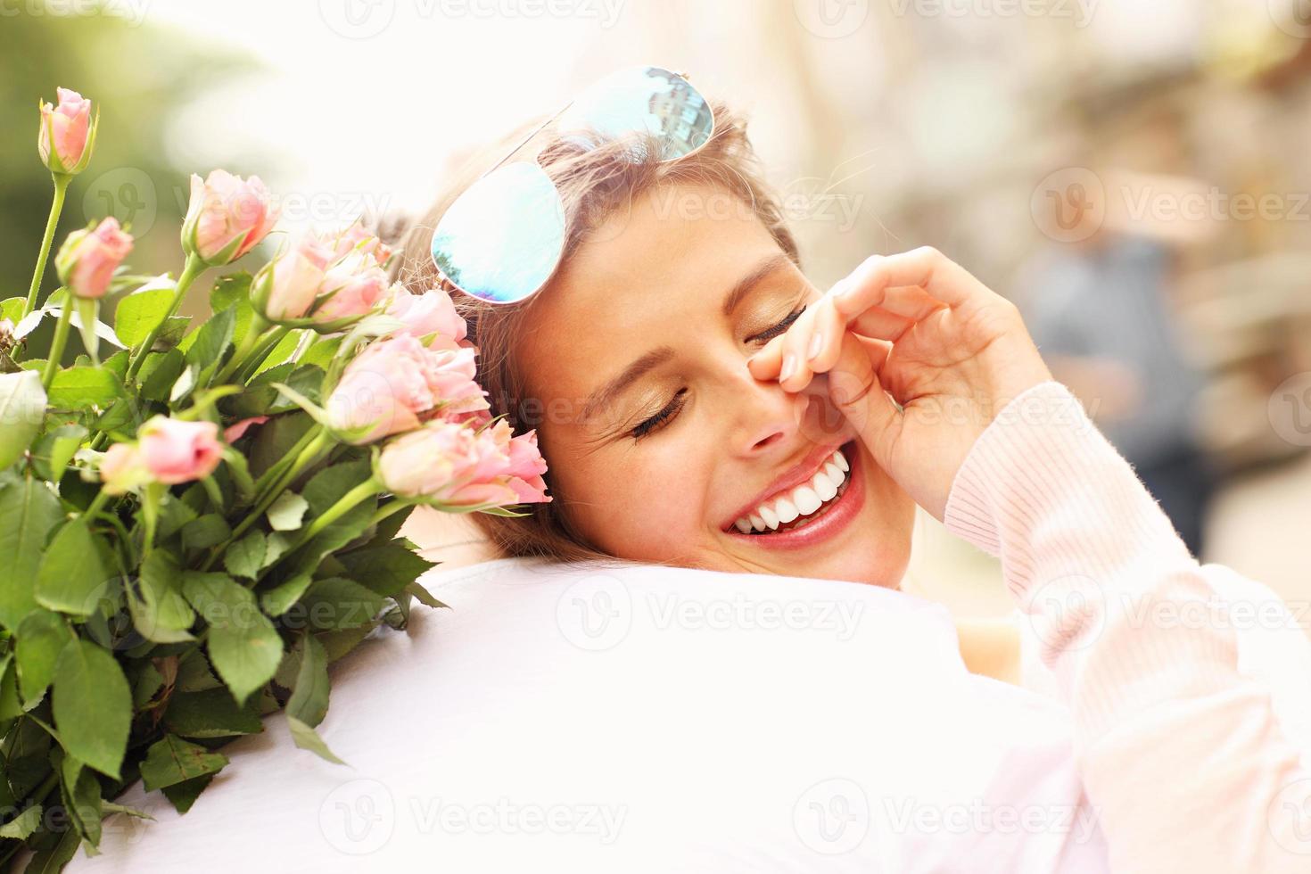 jolie femme tenant des fleurs et étreignant un homme photo