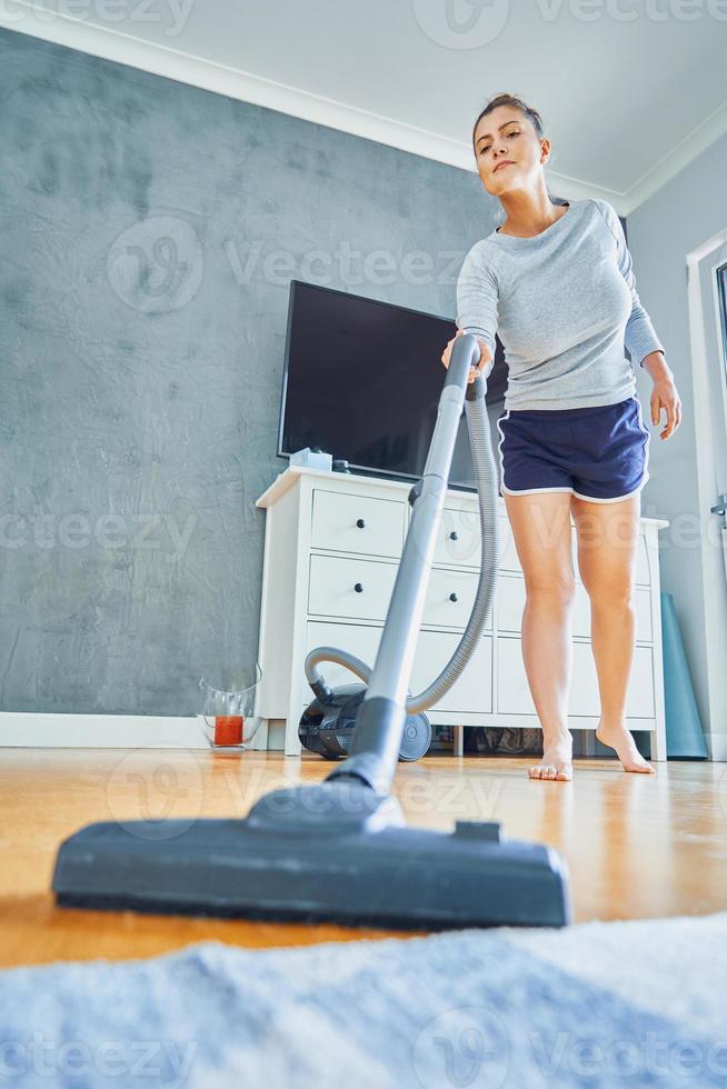 photo d'une femme qui nettoie sa maison à l'aide d'un aspirateur