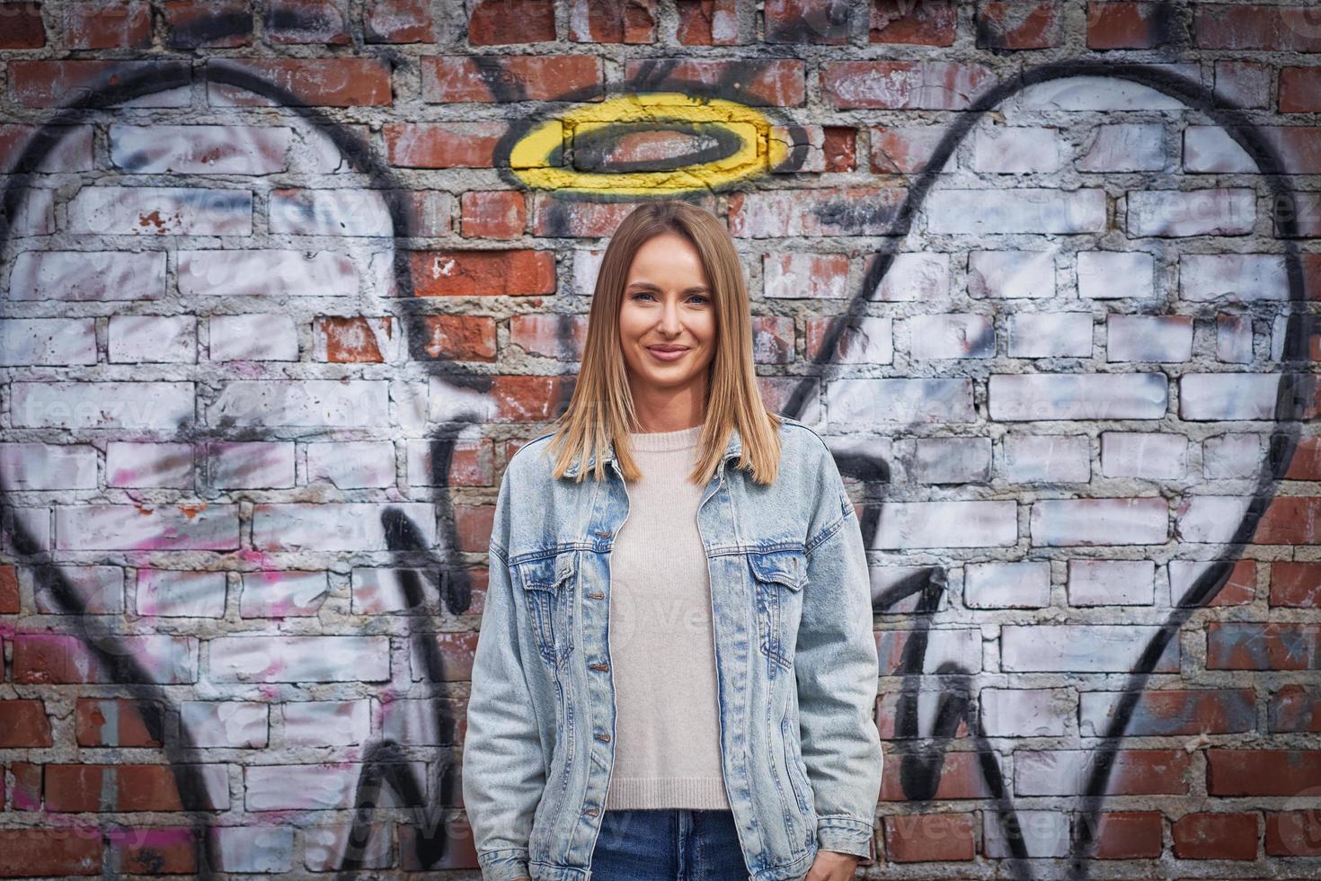 Jeune femme adulte avec une aile d'ange sur le mur photo