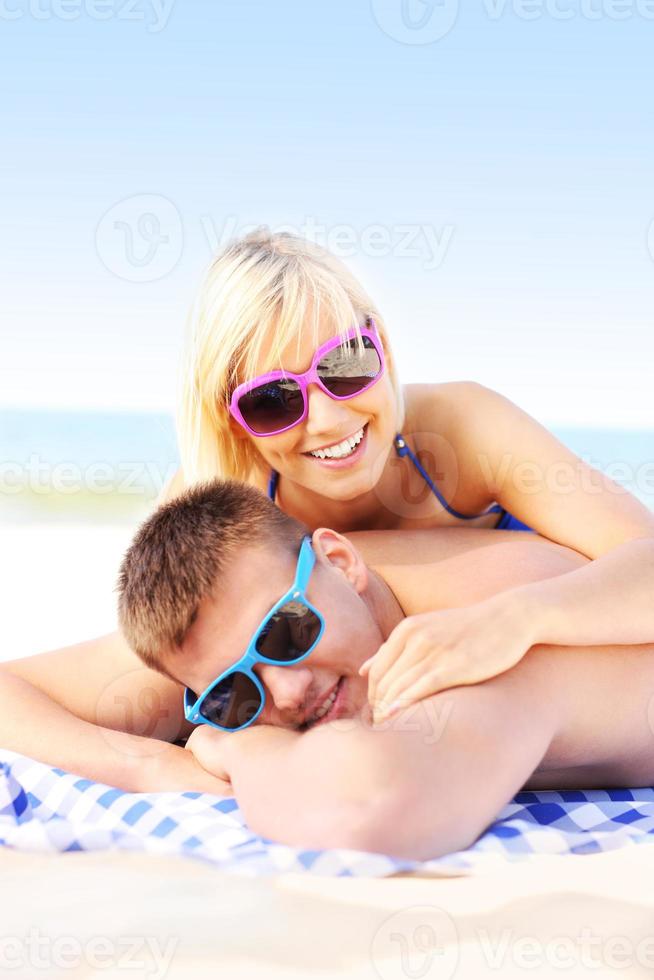 couple adulte prenant un bain de soleil à la plage photo