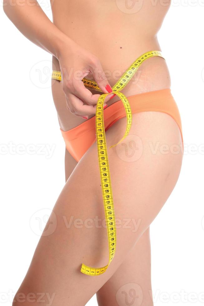 grosse femme mesurant sa ligne de taille avec un ruban à mesurer photo