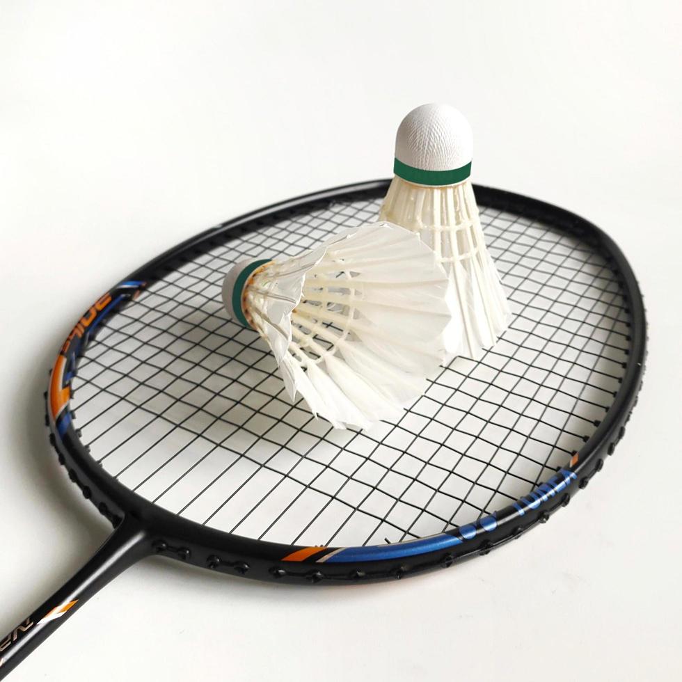 Raquettes de badminton et deux volants de plumes d'intérieur isolés sur blanc photo