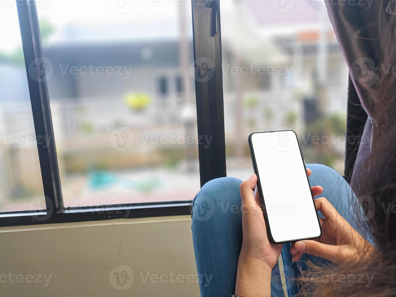 gros plan d'une main de femme tenant un écran blanc de smartphone est vierge .maquette. photo