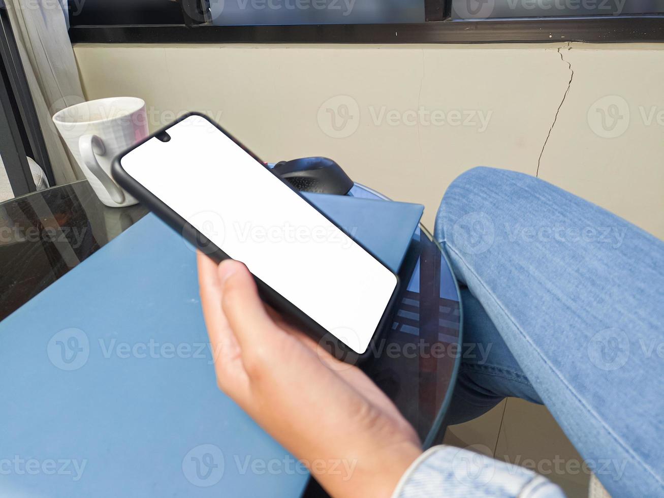 gros plan d'une main de femme tenant un écran blanc de smartphone est vierge .maquette. photo