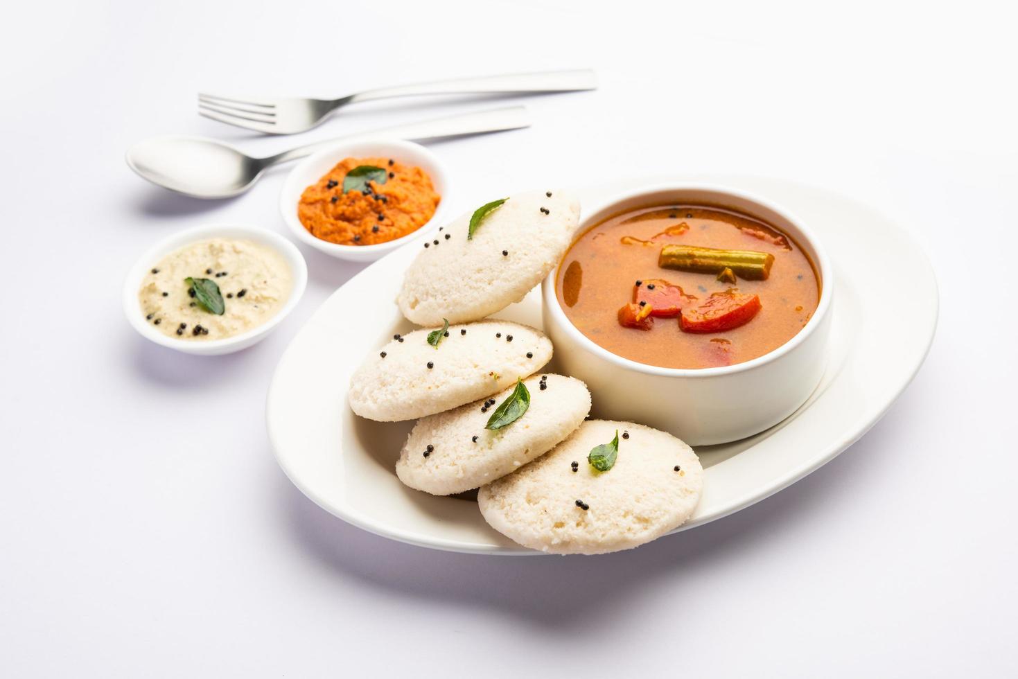 paresseusement sambar ou idli avec sambhar et chutney vert et rouge. petit-déjeuner populaire du sud de l'Inde photo