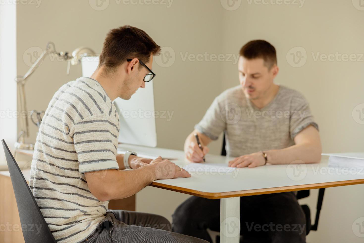 homme professionnel sérieux consultant client au bureau. deux hommes se réunissant, faisant une conversation d'affaires. assureur donnant des conseils, gestionnaire faisant une offre. mentor enseignant stagiaire. entretien d'embauche. photo