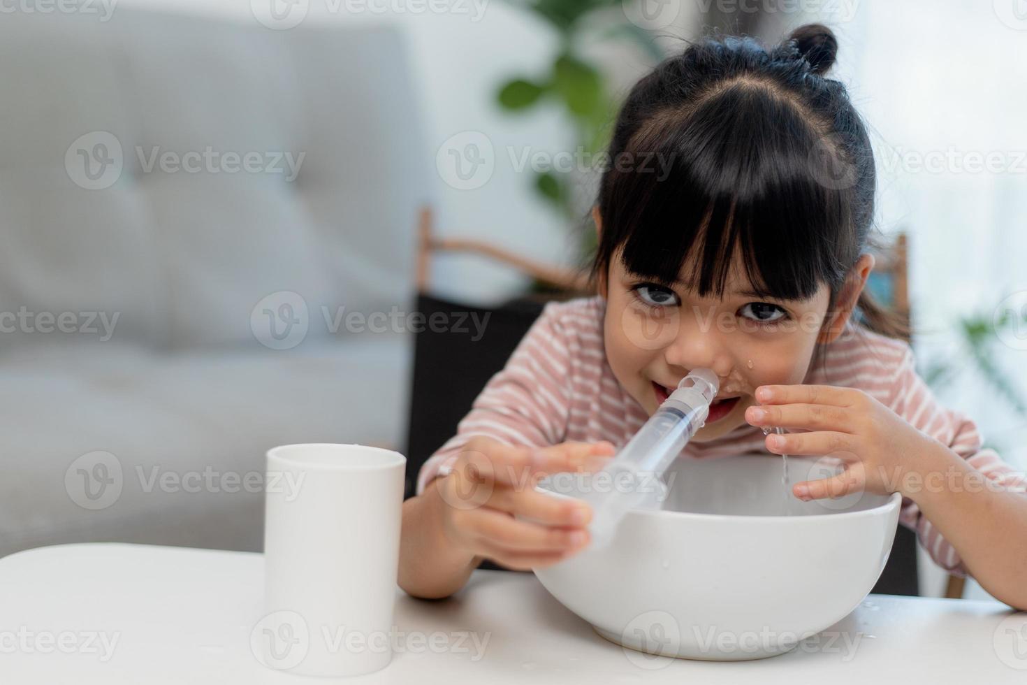 petite fille asiatique nez de lavage nasal salin à la maison