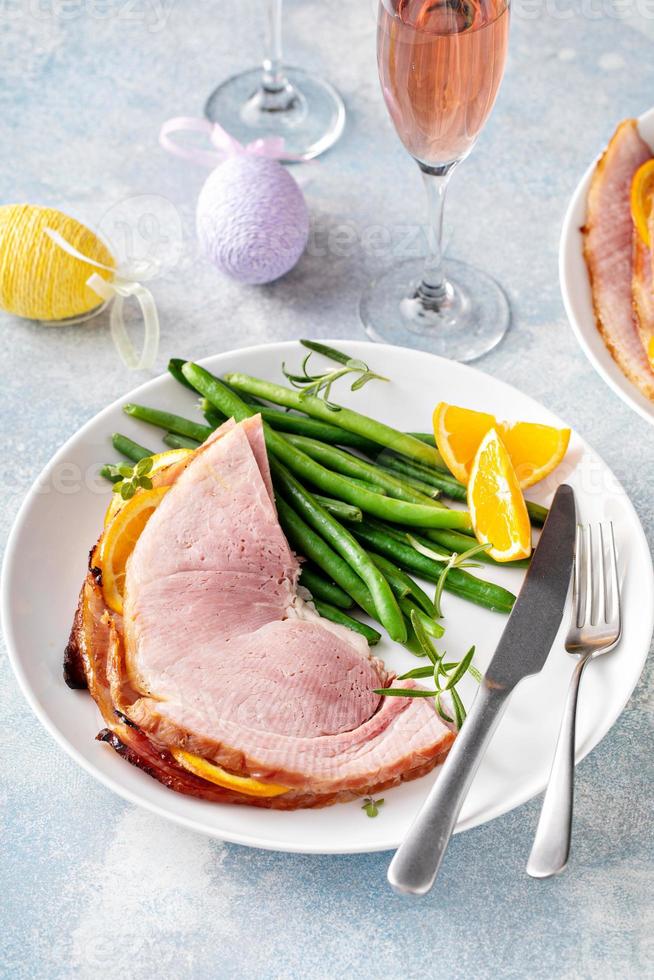 jambon cuit au four de pâques servi sur une assiette avec des haricots verts photo