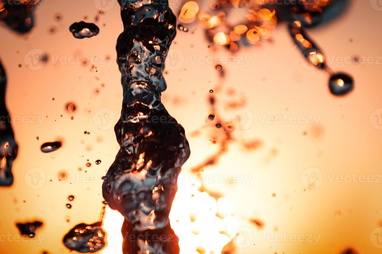 jets d'eau avec beaucoup de gouttes et de bulles sous les rayons du soleil sur fond bleu. un grand plan la texture des vagues d'eau d'une grande fontaine photo