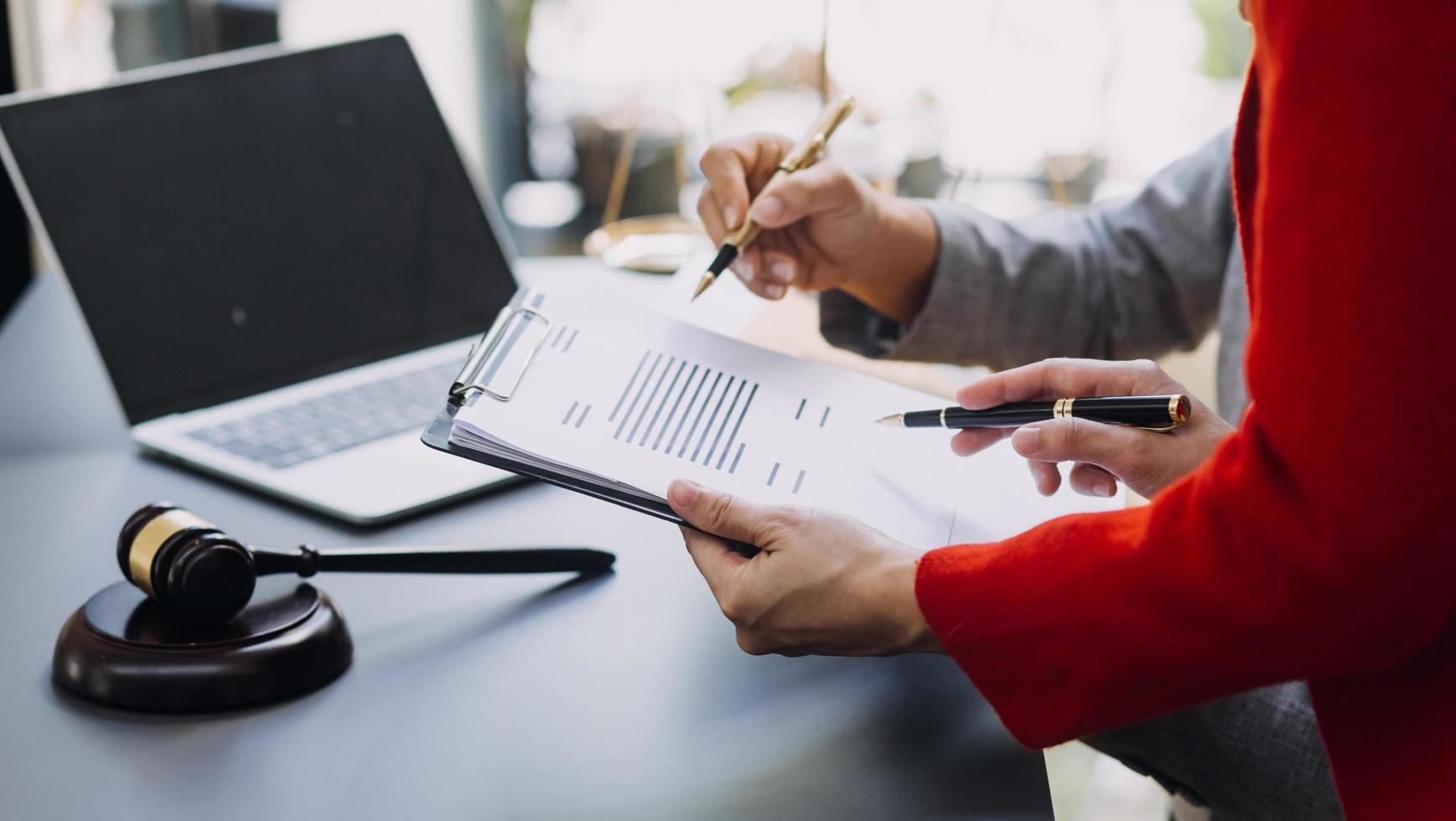 affaires et avocats discutant des documents contractuels avec une échelle en laiton sur le bureau au bureau. droit, services juridiques, conseils, image de concept de justice et de droit avec effet de grain de film photo