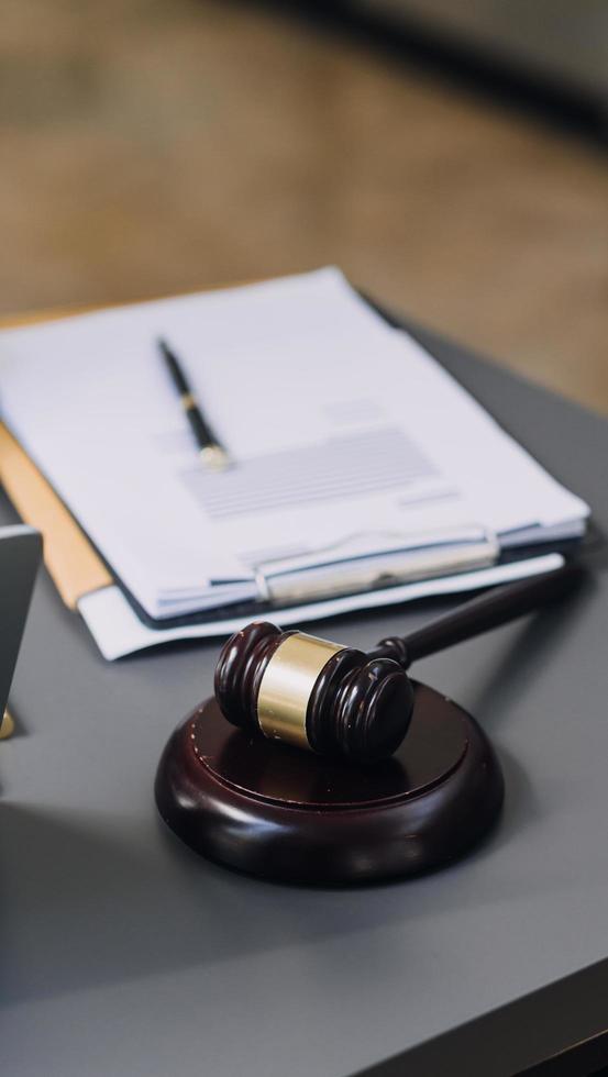 concept de justice et de droit. juge masculin dans une salle d'audience avec le marteau, travaillant avec, clavier d'ordinateur et d'accueil, lunettes, sur table à la lumière du matin photo