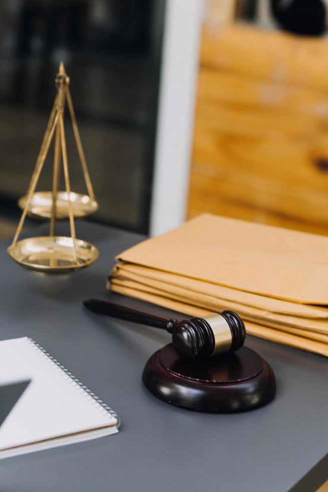 concept de justice et de droit. juge masculin dans une salle d'audience sur une table en bois et conseiller ou avocat masculin travaillant au bureau. concept de droit, de conseil et de justice juridique. photo