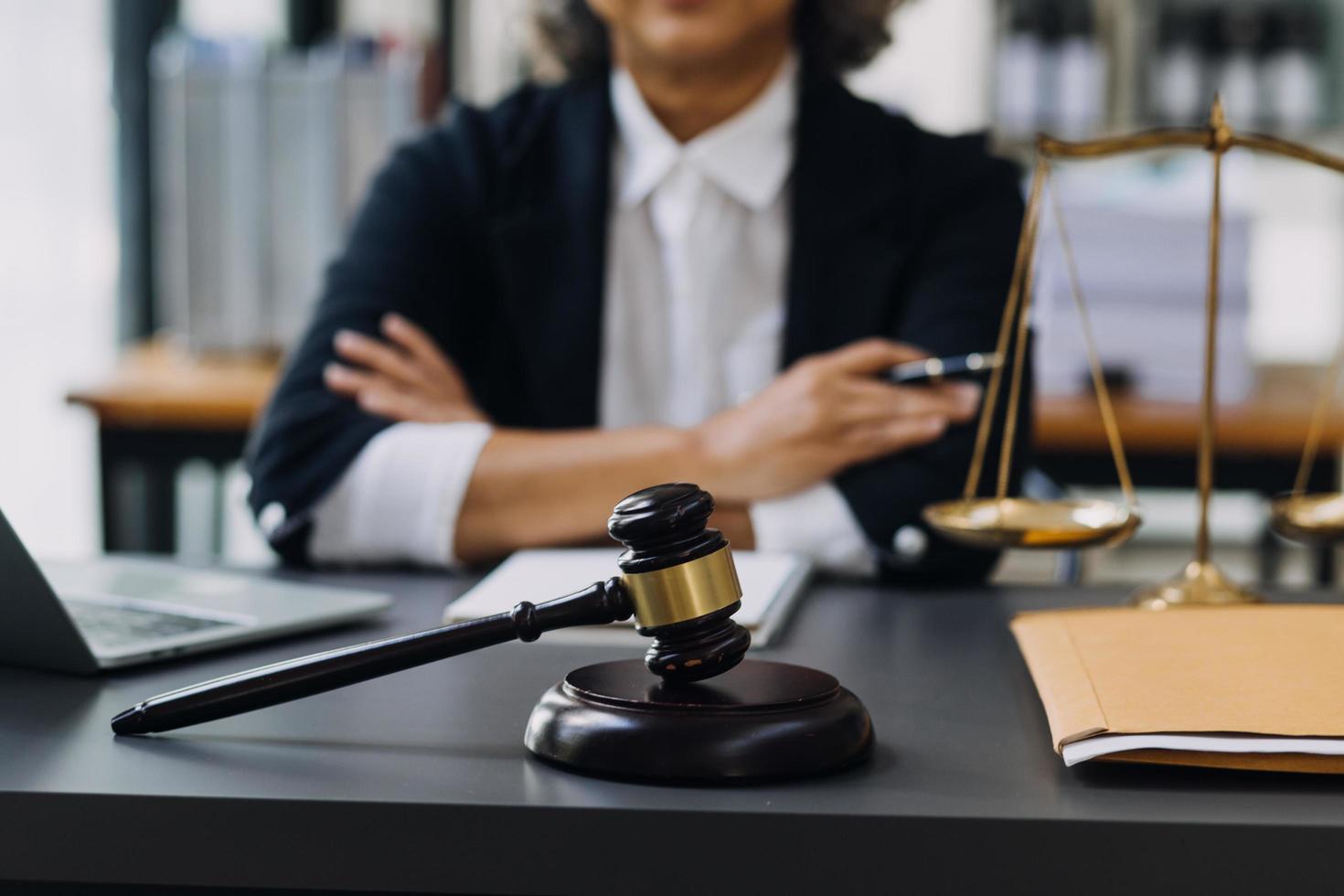 concept de justice et de droit. juge masculin dans une salle d'audience avec le marteau, travaillant avec, clavier d'ordinateur et d'accueil, lunettes, sur table à la lumière du matin photo