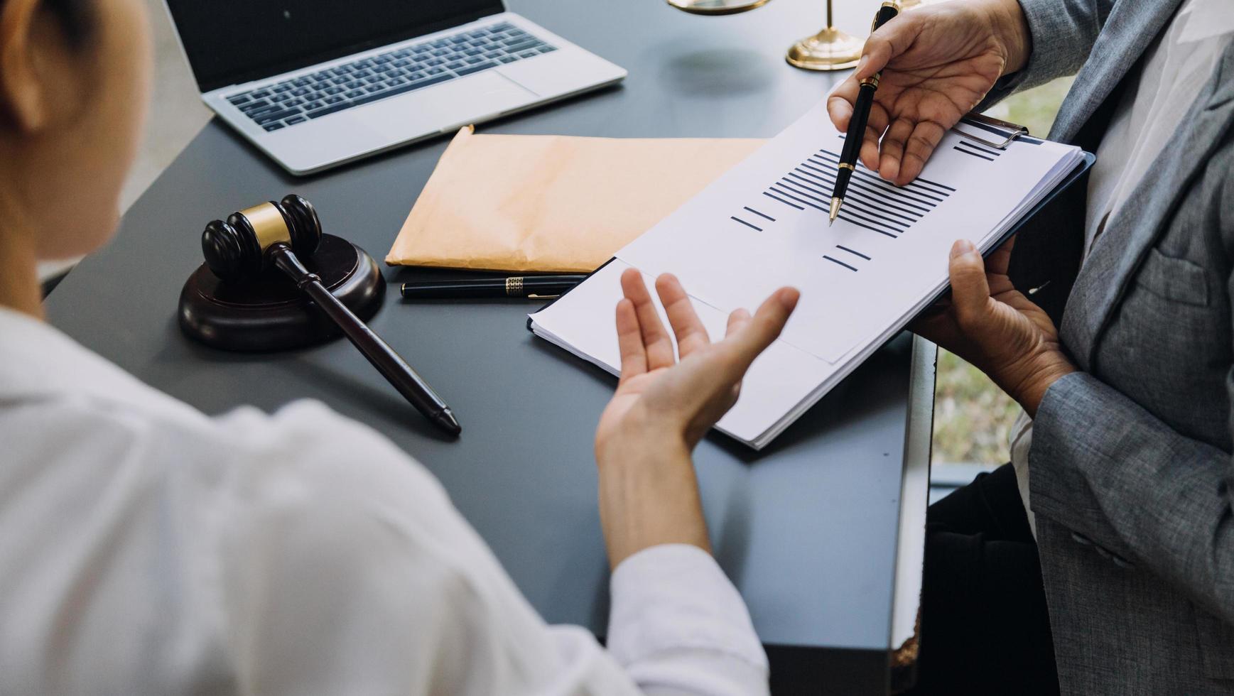 affaires et avocats discutant des documents contractuels avec une échelle en laiton sur le bureau au bureau. droit, services juridiques, conseils, image de concept de justice et de droit avec effet de grain de film photo