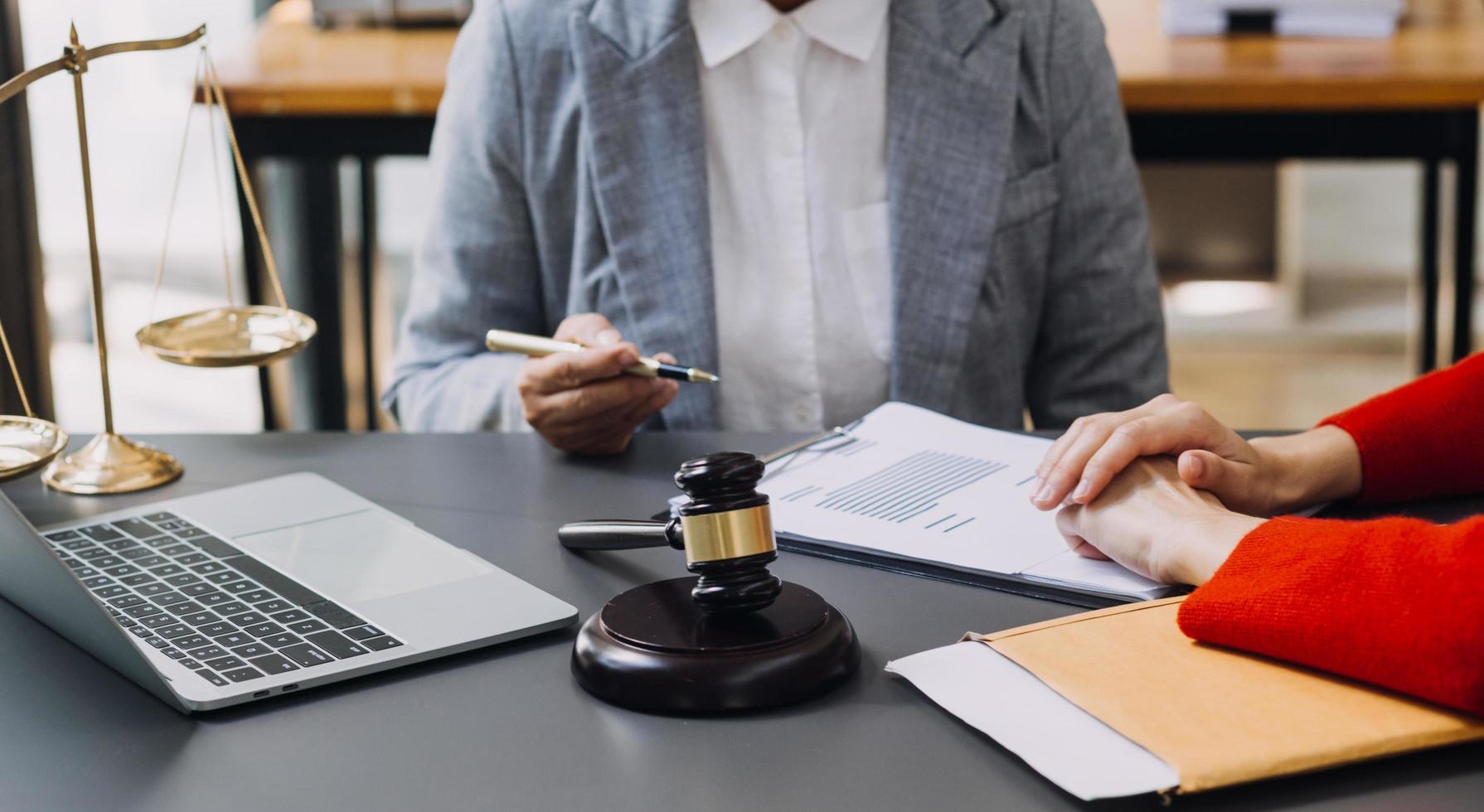 concept de justice et de droit. juge masculin dans une salle d'audience avec le marteau, travaillant avec, clavier d'ordinateur et d'accueil, lunettes, sur table à la lumière du matin photo