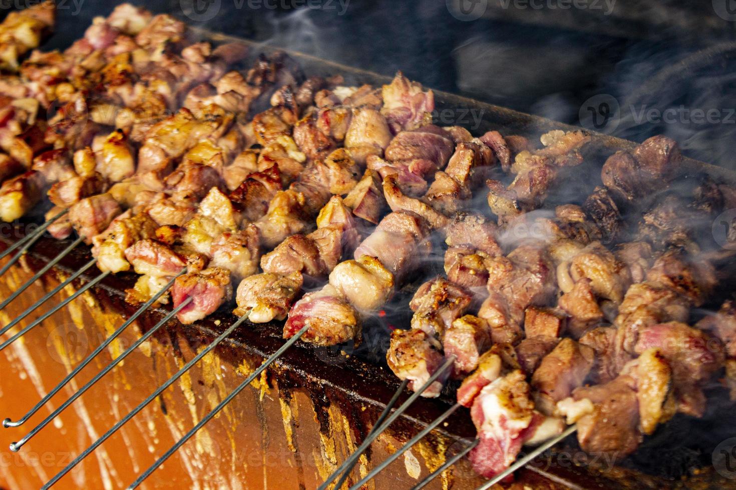 sate klatak ou sate kambing ou satay satay de chèvre, d'agneau, d'agneau ou de viande de chèvre avec un ingrédient de charbon de bois sur des grillades au feu rouge par des gens, indonésie cuisine satay. avec mise au point sélective photo