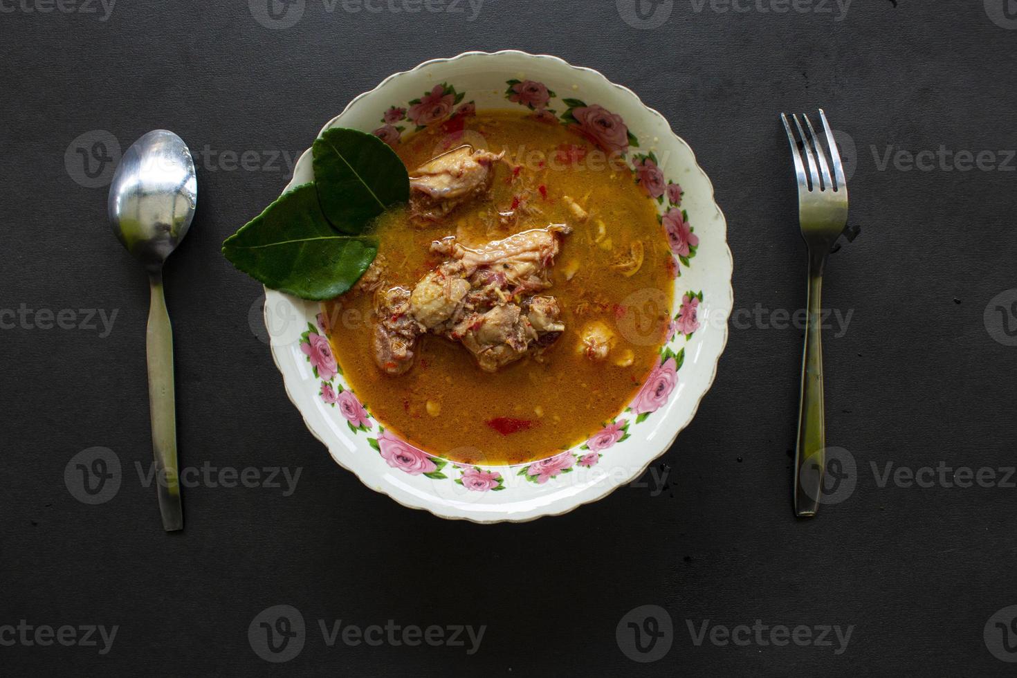 curry de poulet ou kari ayam servi sur bol, isolé sur fond blanc photo