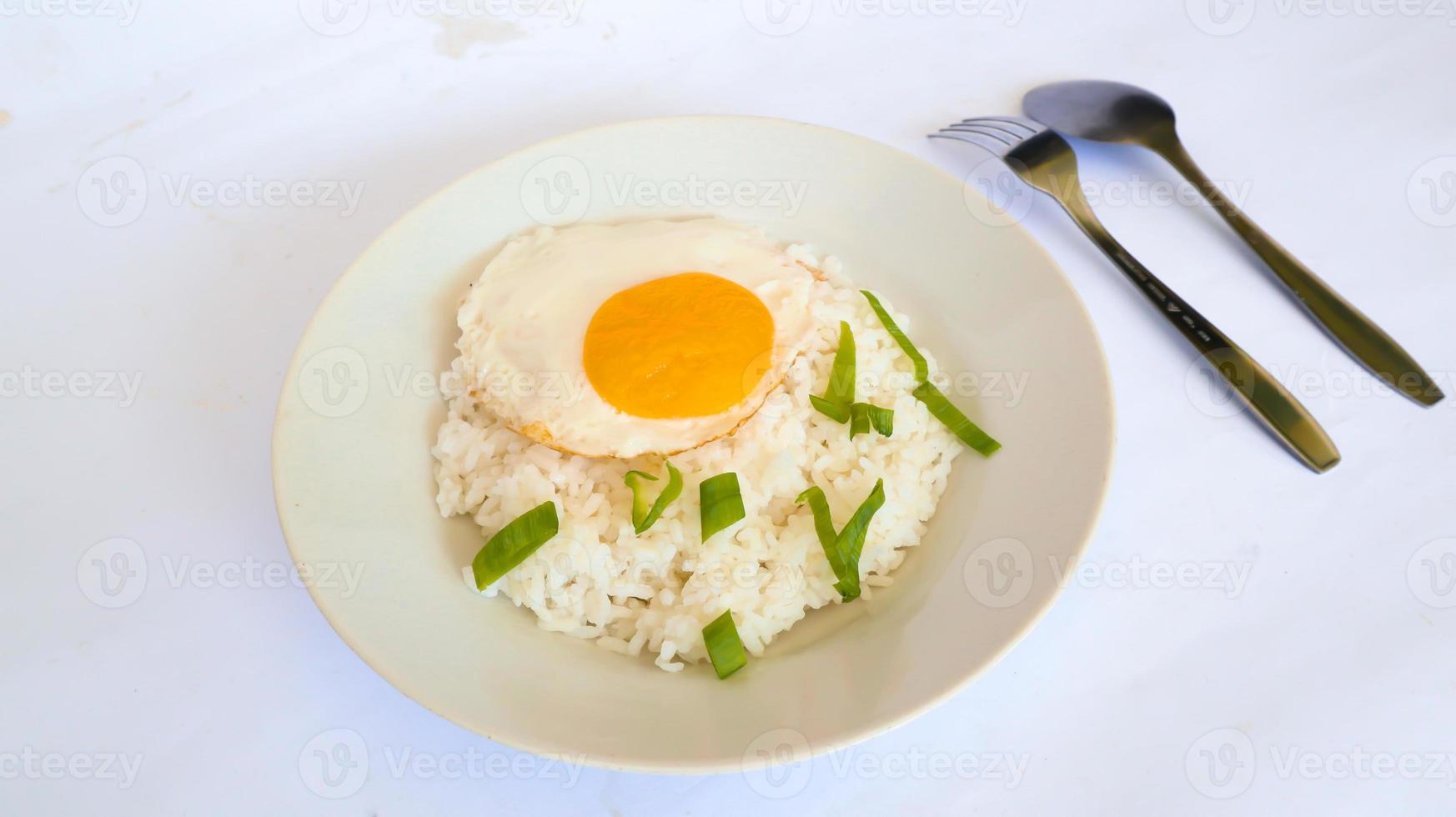 riz aux oeufs frits. Petit-déjeuner œuf au plat riz ensoleillé sur une assiette, isolé sur fond blanc photo