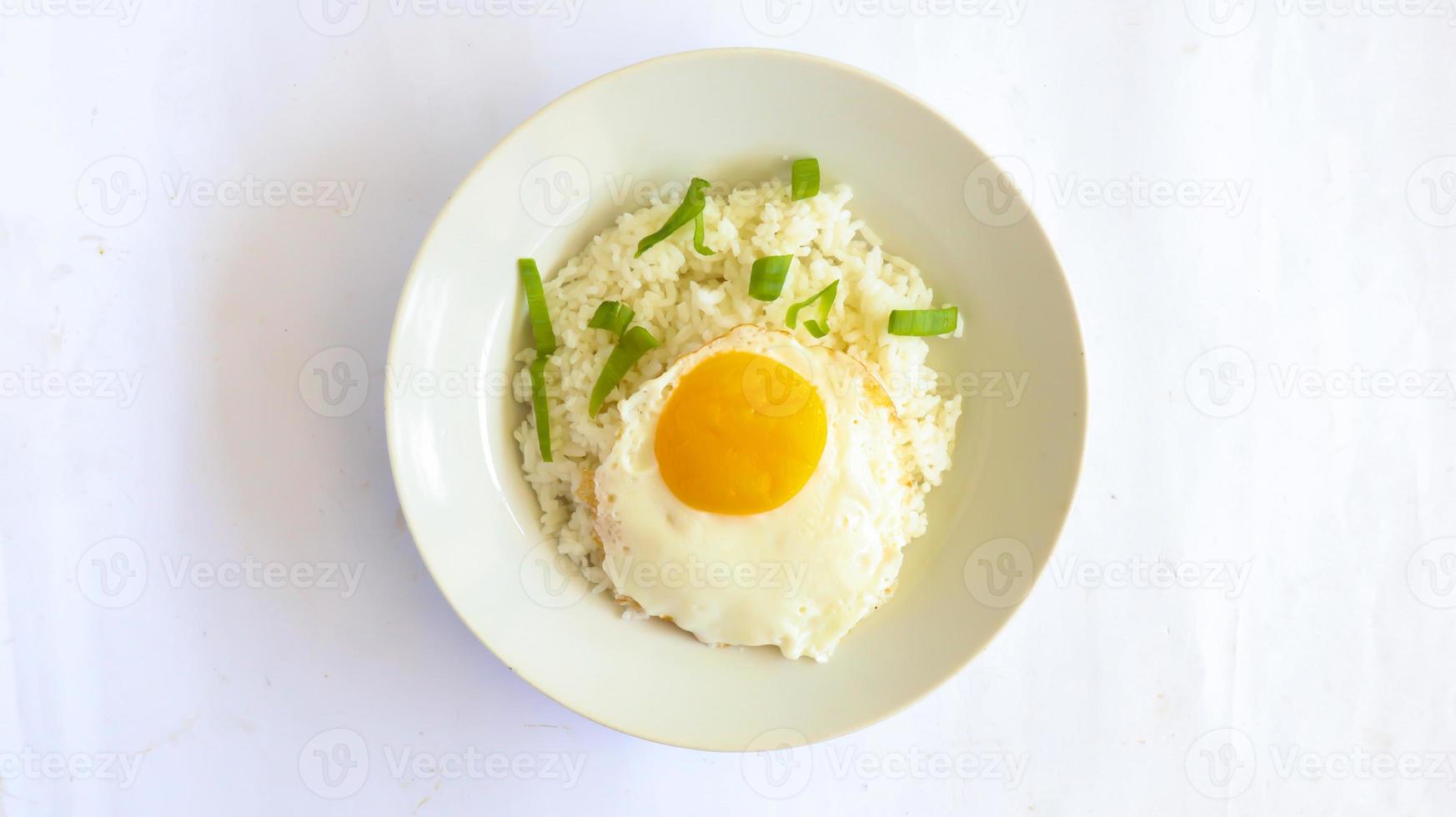 riz aux oeufs frits. Petit-déjeuner œuf au plat riz ensoleillé sur une assiette, isolé sur fond blanc photo