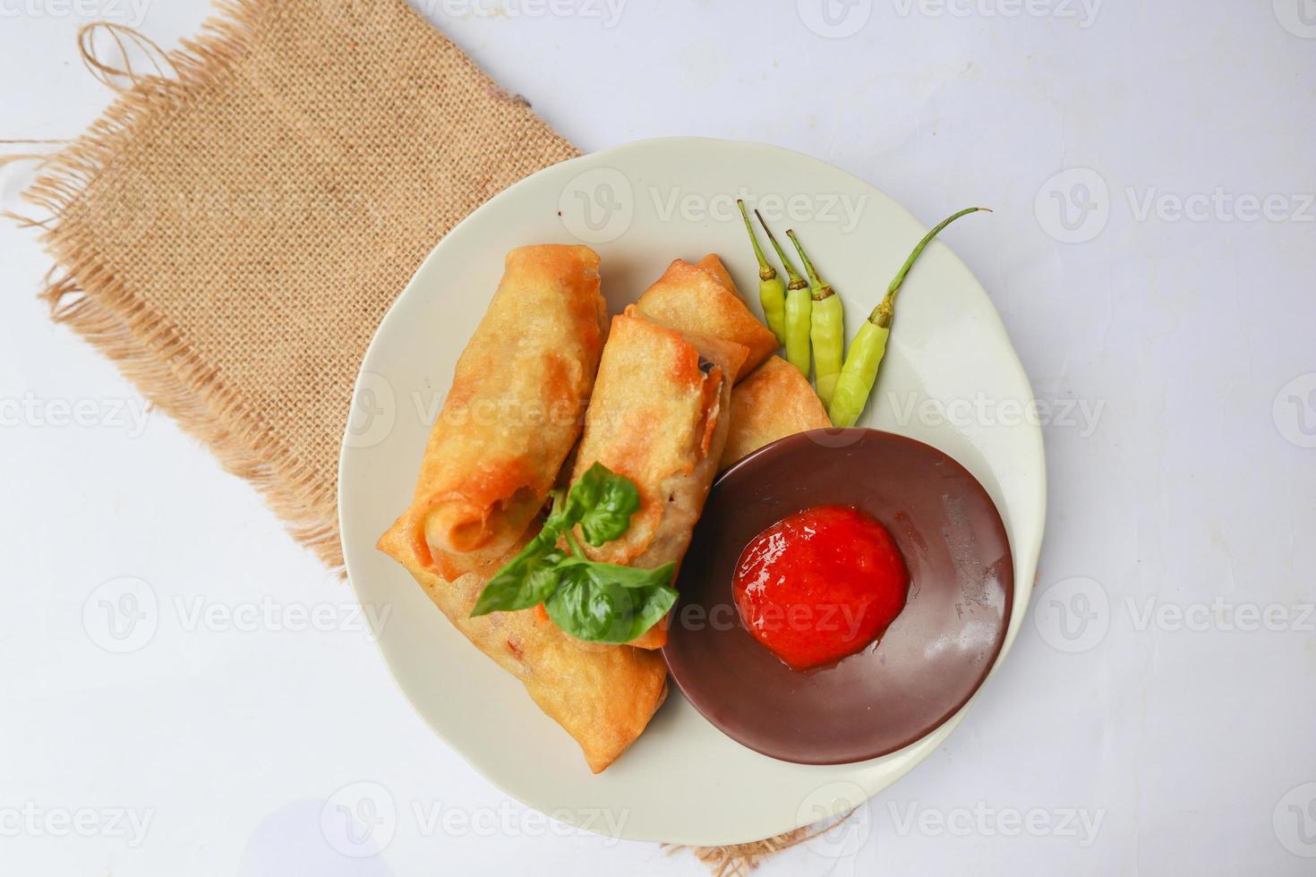 lumpia ou lunpia, est un en-cas traditionnel à base de rouleaux de printemps de semarang, en indonésie. nems traditionnels aux oeufs, poulet ou crevettes, sautés de pousses de bambou. isolé sur fond blanc photo