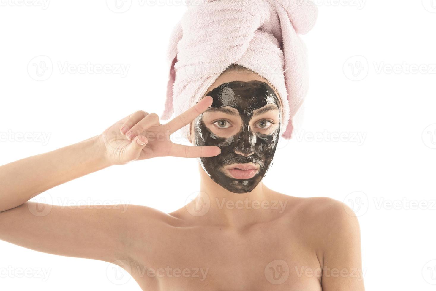 belle fille avec un masque cosmétique facial noir. notion de beauté. isolée photo