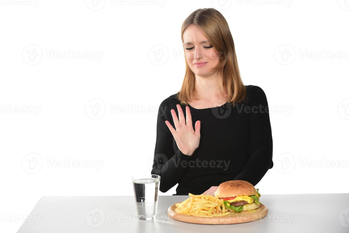 portrait d'une belle jeune fille drôle mangeant un hamburger photo