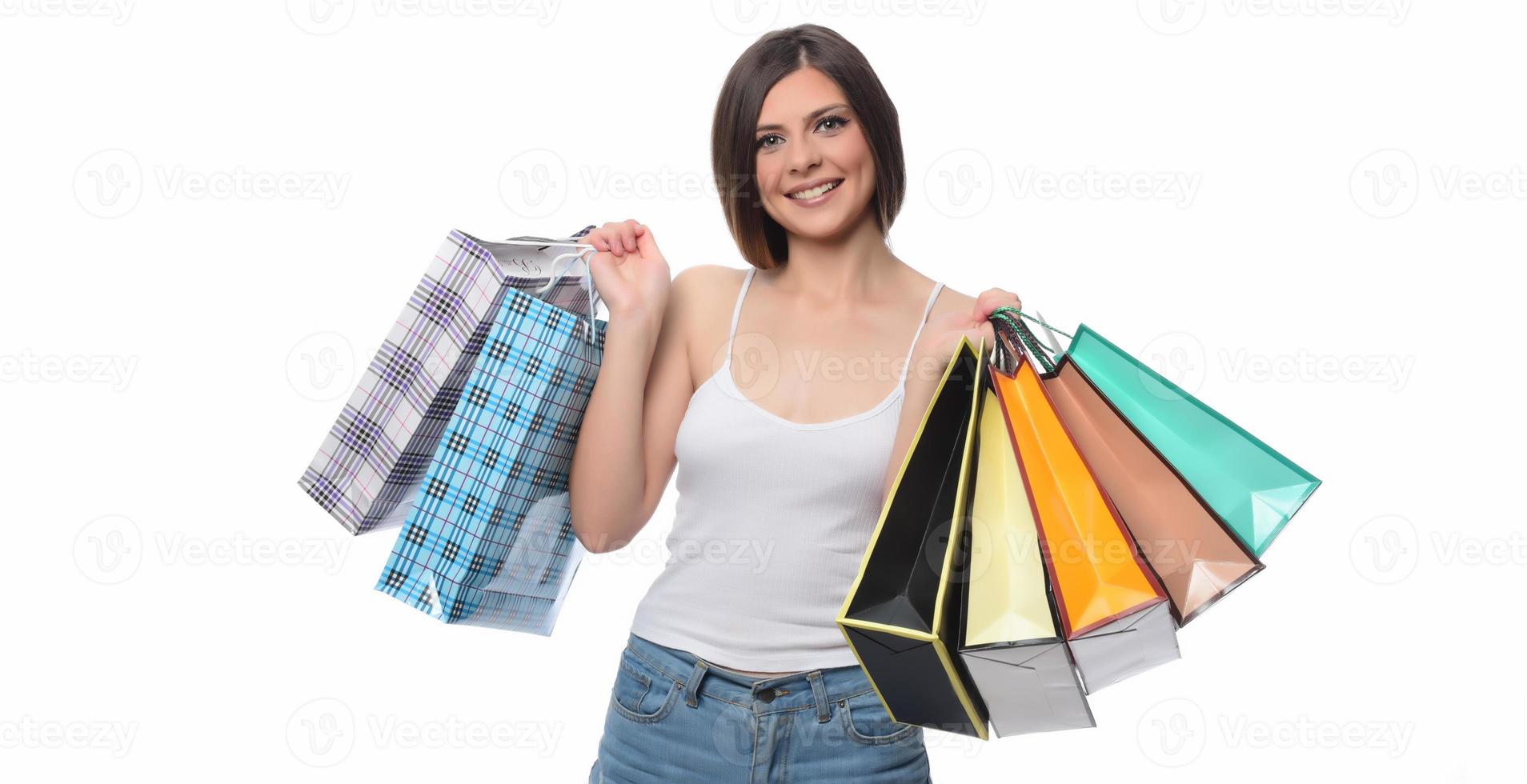 image d'une belle jeune femme brune posant avec des sacs à provisions et regardant la caméra. notion d'achat. isolée photo