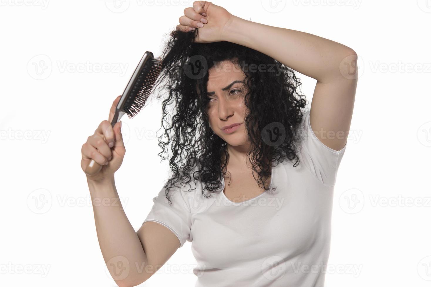 Belle femelle avec un peigne coincé dans les cheveux bouclés photo