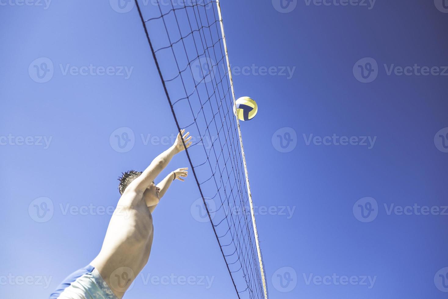 un enfant joue au volley-ball par une belle journée d'été photo