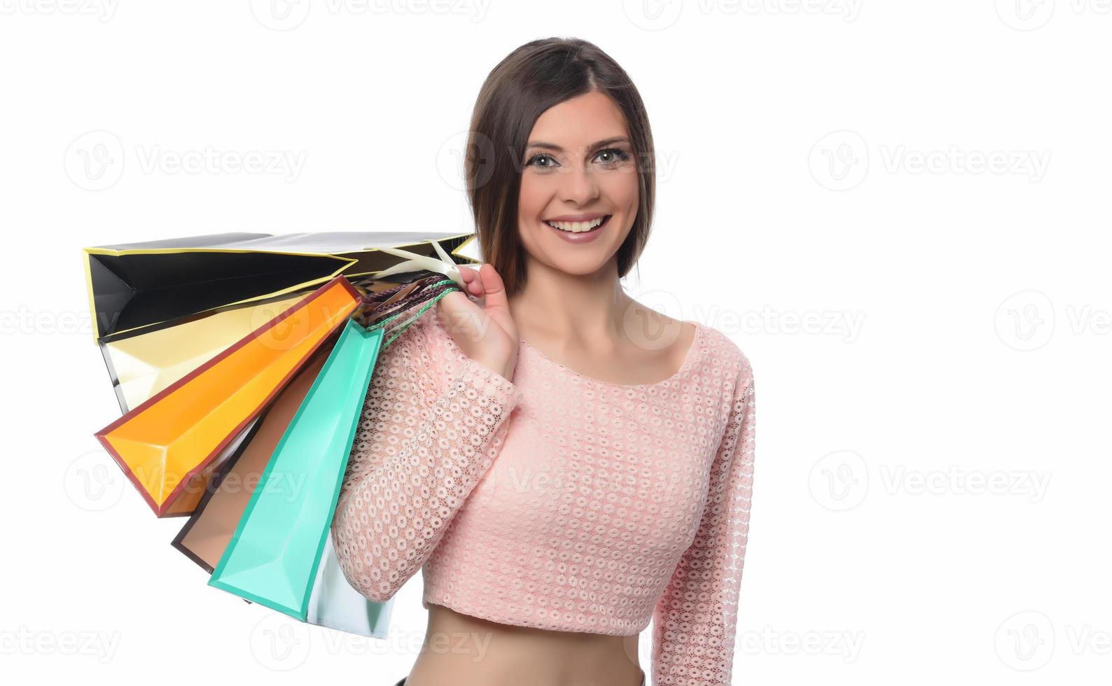 image d'une belle jeune femme brune posant avec des sacs à provisions et regardant la caméra. notion d'achat. isolée photo