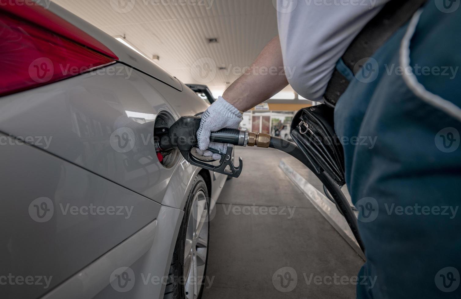 pompage de gaz à la pompe à gaz. Gros plan de l'homme de pompage de carburant essence en voiture à la station-service. photo