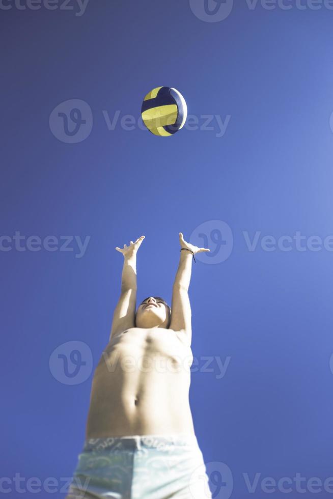 un enfant joue au volley-ball par une belle journée d'été photo