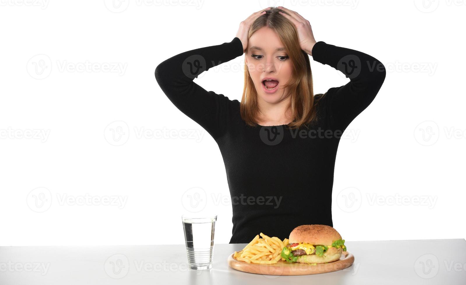 portrait d'une belle jeune fille drôle mangeant un hamburger photo