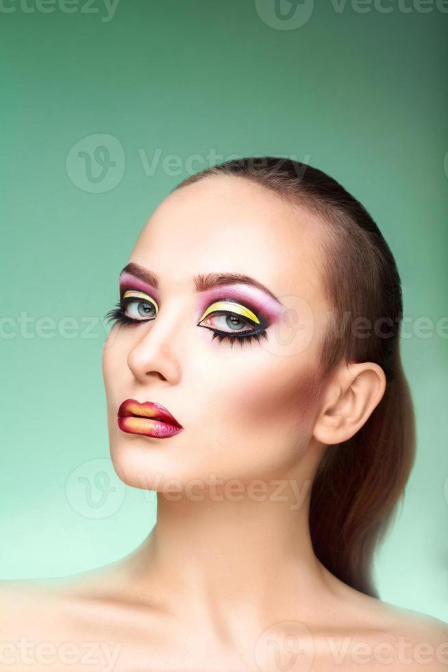 jolie femme avec maquillage multicolore sur fond vert photo