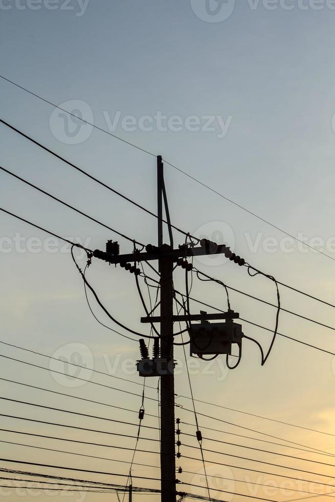 le pôle électrique moyenne tension grand public est le peuple qui utilise l'énergie et la petite industrie dans l'atmosphère chaleureuse et romantique du ciel du soir photo