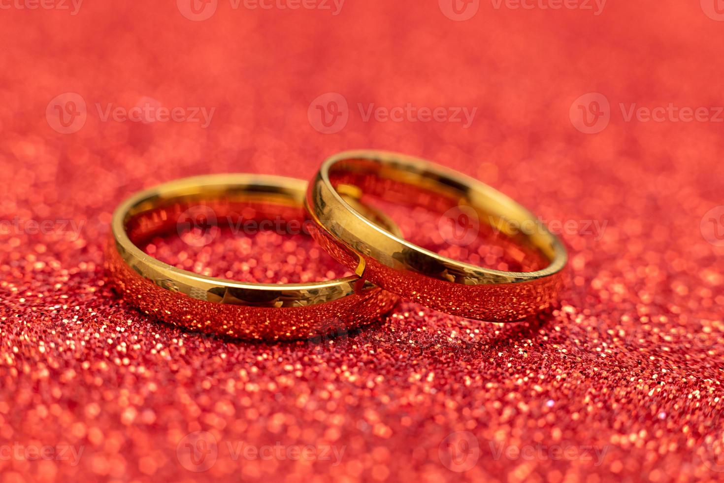 veux-tu m'épouser. deux anneaux de mariage dorés sur fond de paillettes rouges. concept de mariage de proposition de mariage de fiançailles. St. carte postale de la saint valentin. bannière le jour de la saint valentin. espace de copie. photo