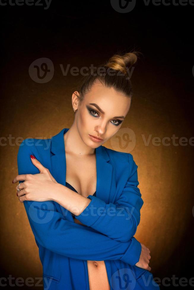 belle jeune fille en veste bleue avec maquillage de beauté en studio photo