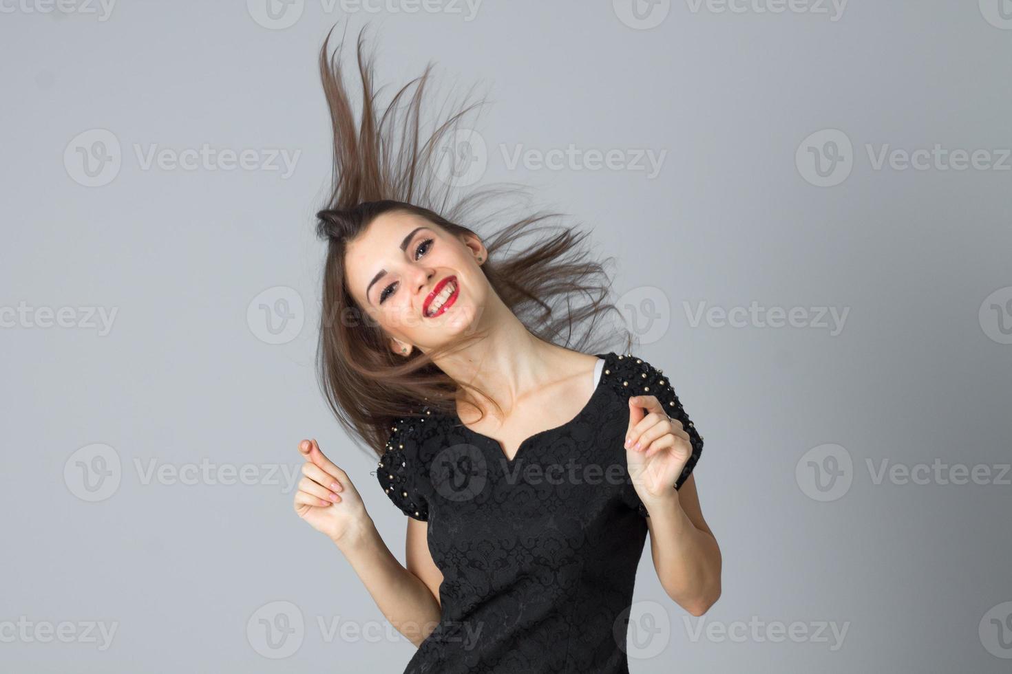 fille en robe noire posant en studio photo