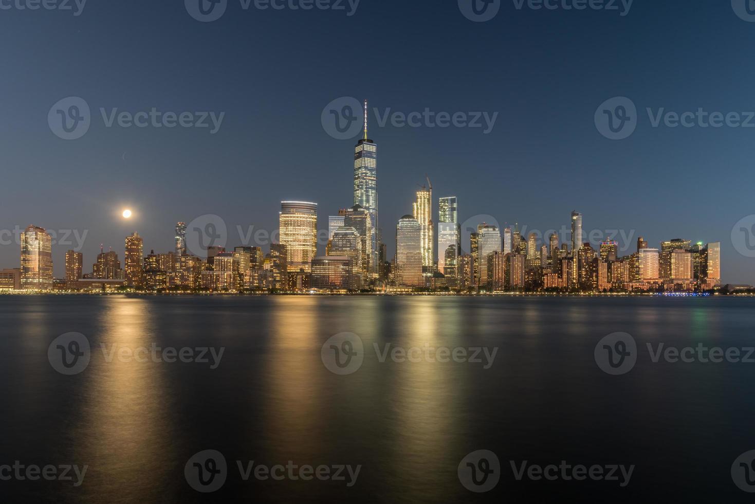 horizon de new york vu de l'autre côté de la rivière hudson dans le new jersey au crépuscule avec la super lune en arrière-plan. photo